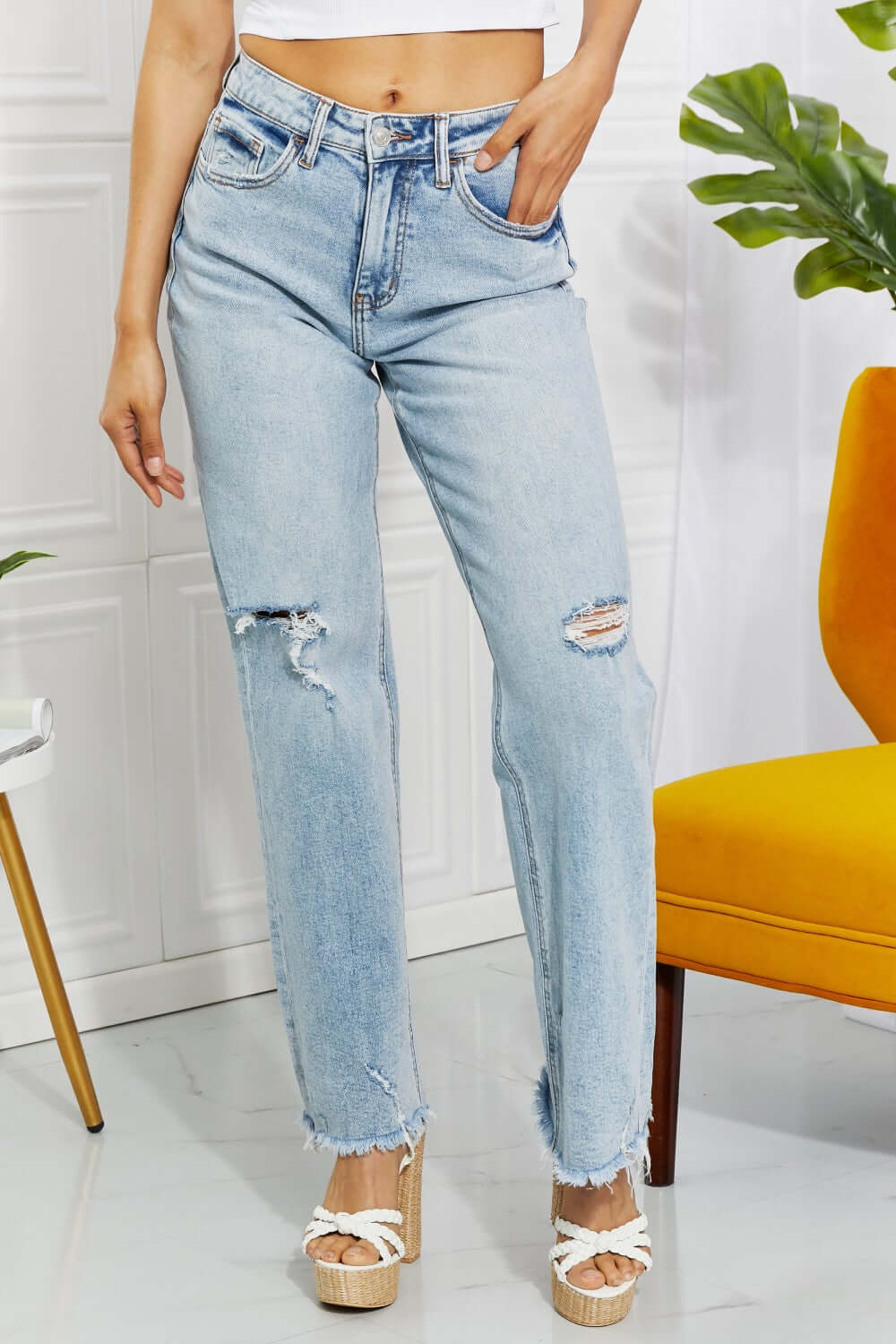 Distressed light wash high waist Allie 90's Dad Jeans with raw hem and cat's whiskers fading, styled with casual wedges.