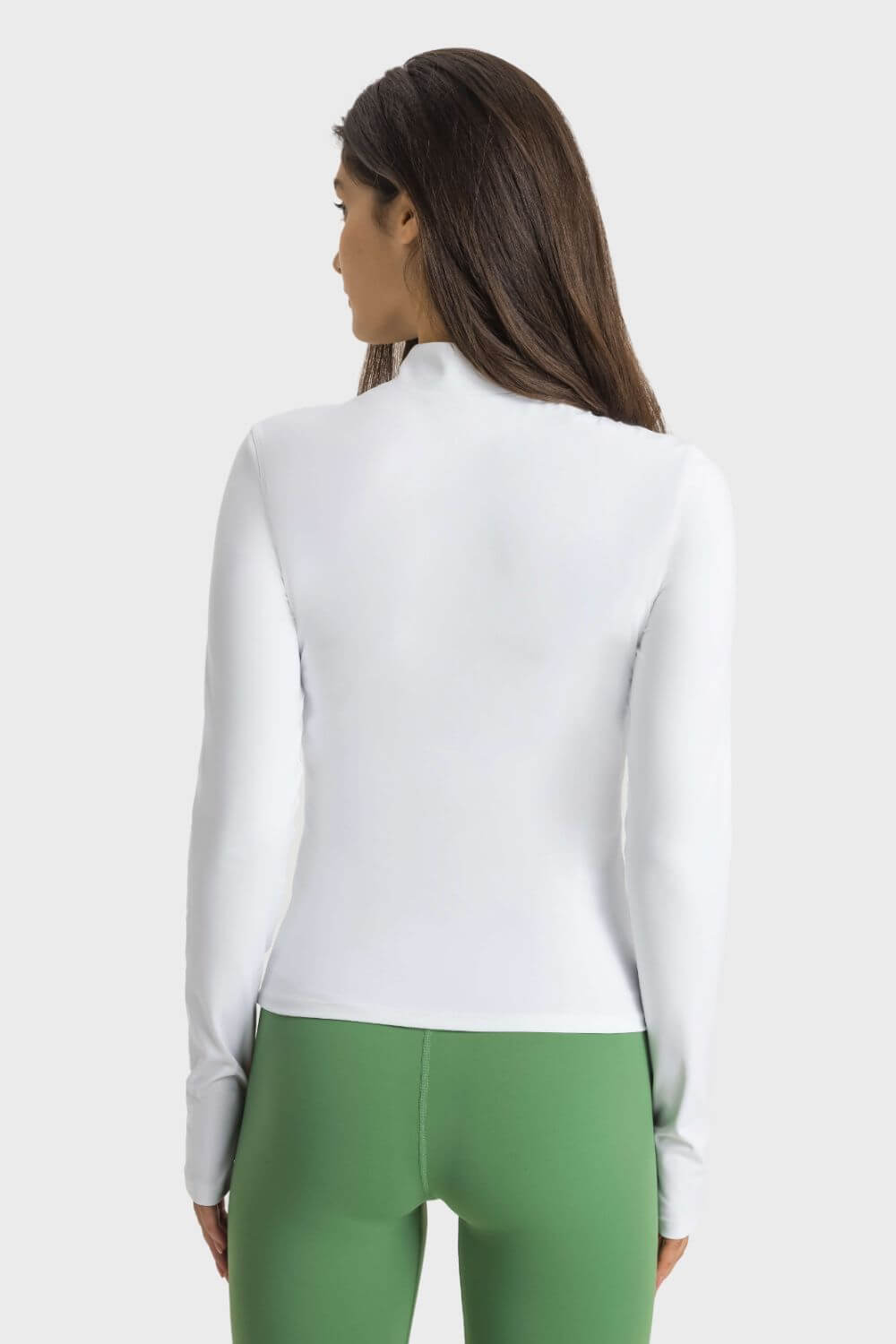 Back view of Millennia Half Zip Thumbhole Sleeve Sports Top in white, paired with green leggings, perfect for workouts.