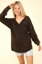 Woman wearing VERY J Washed V-Neck Exposed Seam Knit Top with drop shoulder design, long sleeves, and raw edge detail.