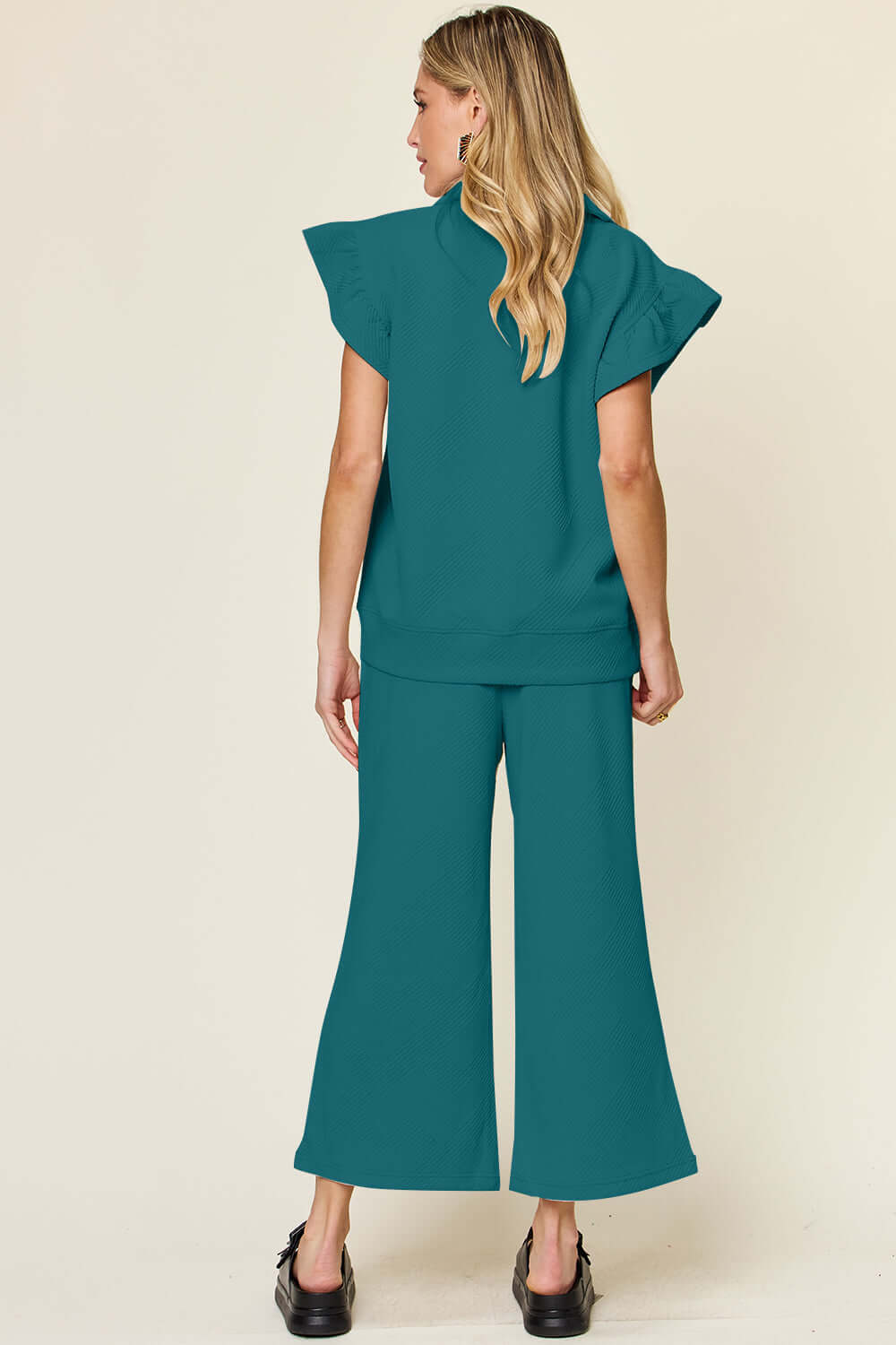 Woman wearing teal Texture Ruffle Short Sleeve Top and Drawstring Wide Leg Pants Set from the back.