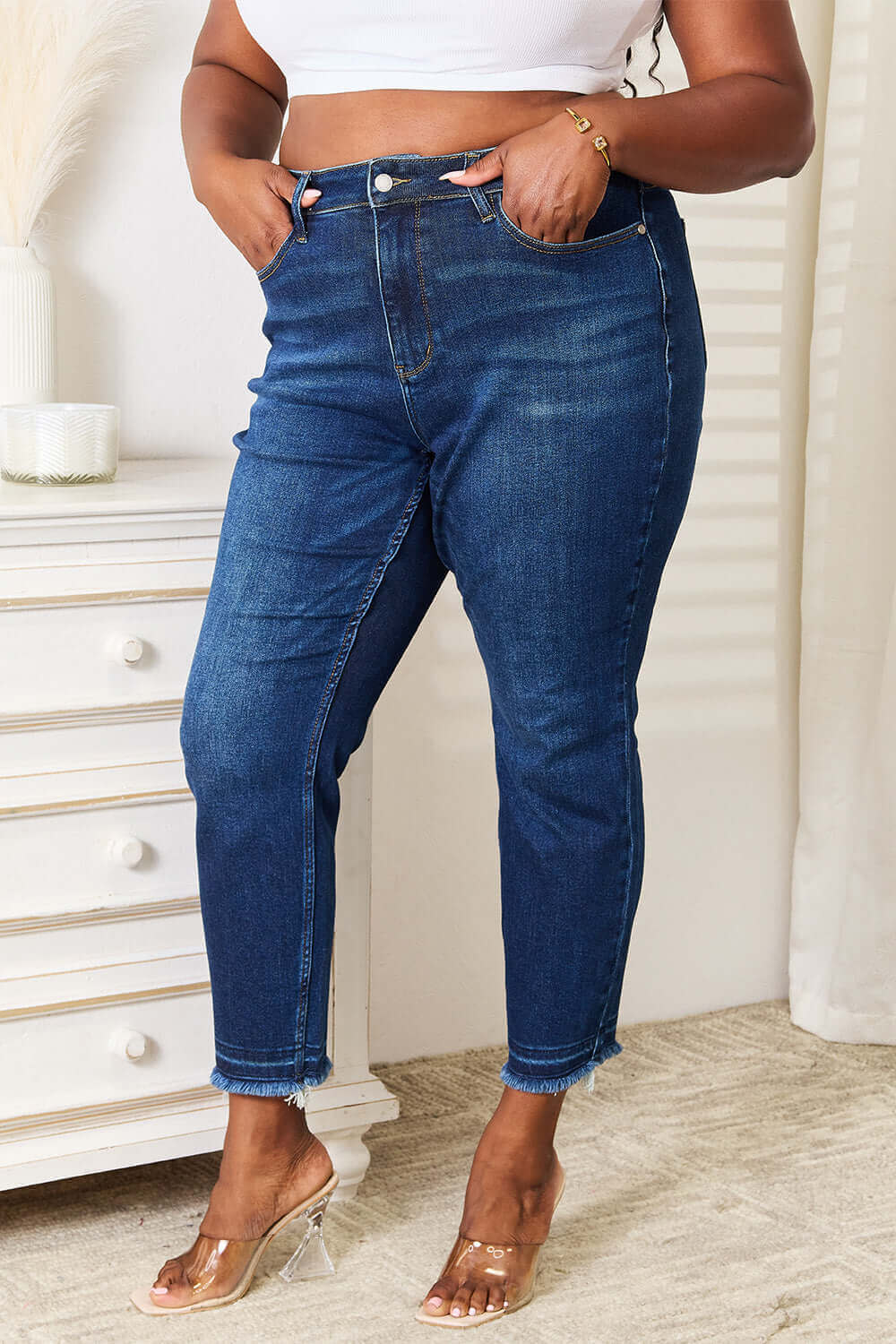 Model wearing Judy Blue High Waist Released Hem Slit Jeans in deep indigo wash with a flattering fit and slim silhouette.