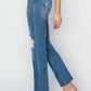 Side view of high rise distressed ankle jeans by Risen Jeans styled with clear heels.