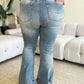 Woman wearing High Waist Flare Judy Blue Jeans showcasing the back view and vintage-inspired silhouette in a stylish setting.