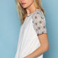 Woman wearing Lace Short Sleeve Exposed Seam T-Shirt with delicate lace detailing on sleeves, styled with jeans.