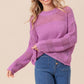 Woman wearing BiBi Openwork Long Sleeve Knit Top in pink paired with blue jeans.