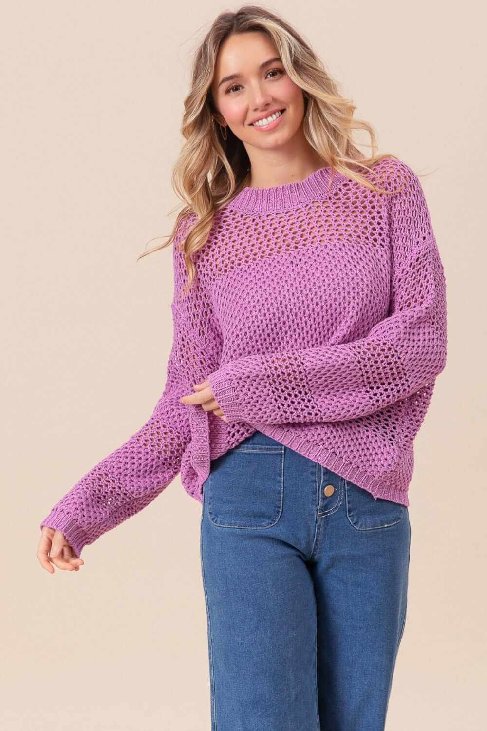 Woman wearing BiBi Openwork Long Sleeve Knit Top in pink paired with blue jeans.