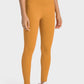 Model showcasing Millennia High-Rise Wide Waistband Yoga Leggings in mustard, perfect for yoga and activewear.