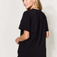 Woman wearing black graphic round neck short sleeve t-shirt with blue jeans, back view.