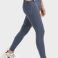 Model showcasing Millennia V-Waist Yoga Leggings in blue, featuring pockets and a flattering fit. Perfect for yoga workouts!