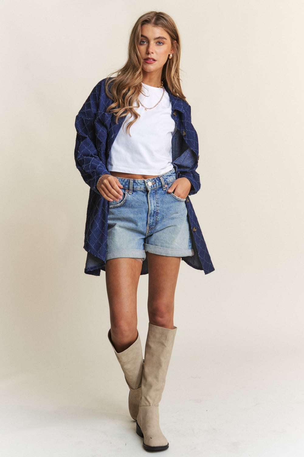 Stylish woman wearing J.NNA Rhombus Stitched Button Up Denim Shacket, paired with denim shorts and beige boots.