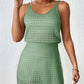 Woman wearing a green openwork V-neck sleeveless cover up dress made of stretchy, sheer acrylic material.