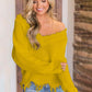 Woman wearing Bella Road frayed hem dropped shoulder yellow sweater with jeans, showcasing playful fashion style.