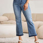 Woman wearing release hem cropped bootcut Judy Blue Jeans with a stylish look in a cozy indoor setting.