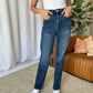 Woman wearing RFM Full Size High Rise Straight Tummy Control Jeans in a living room setting.