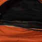 Inside view of an orange nylon backpack bag showcasing its spacious compartments and durable lining.