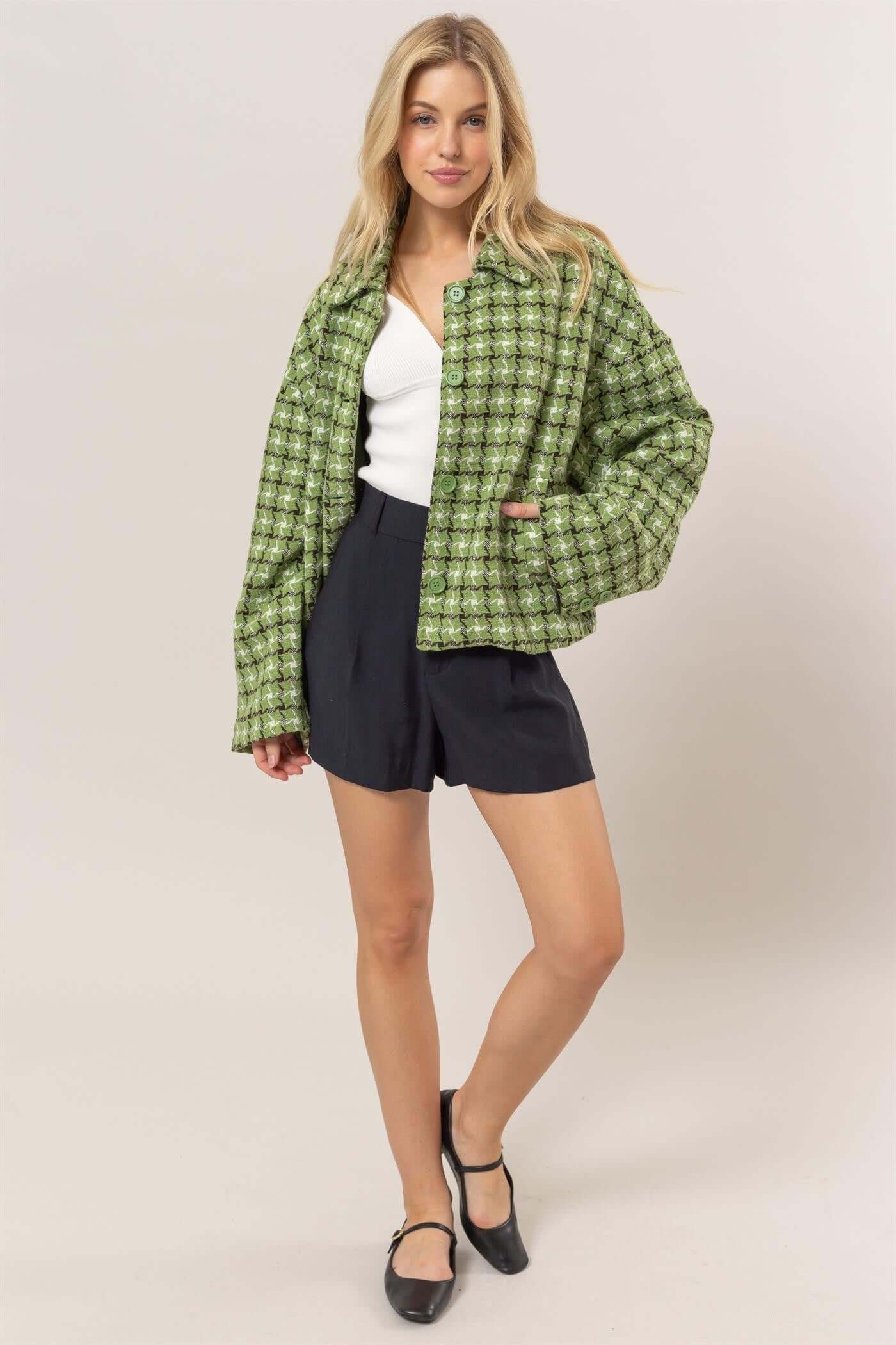 Stylish model in a green tweed plaid button-up collared neck jacket, paired with navy shorts and black shoes.