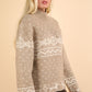 Woman wearing beige Christmas element mock neck long sleeve sweater with festive reindeer and snowflake patterns.