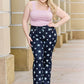 Woman wearing Janelle Full Size High Waist Star Print Flare Jeans by Judy Blue Jeans, featuring a dark wash and star design, standing outside