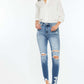 High Rise Frayed Ankle Skinny Jeans in medium wash with distressed detailing and stretch denim, worn by a woman in a white shirt and heels.