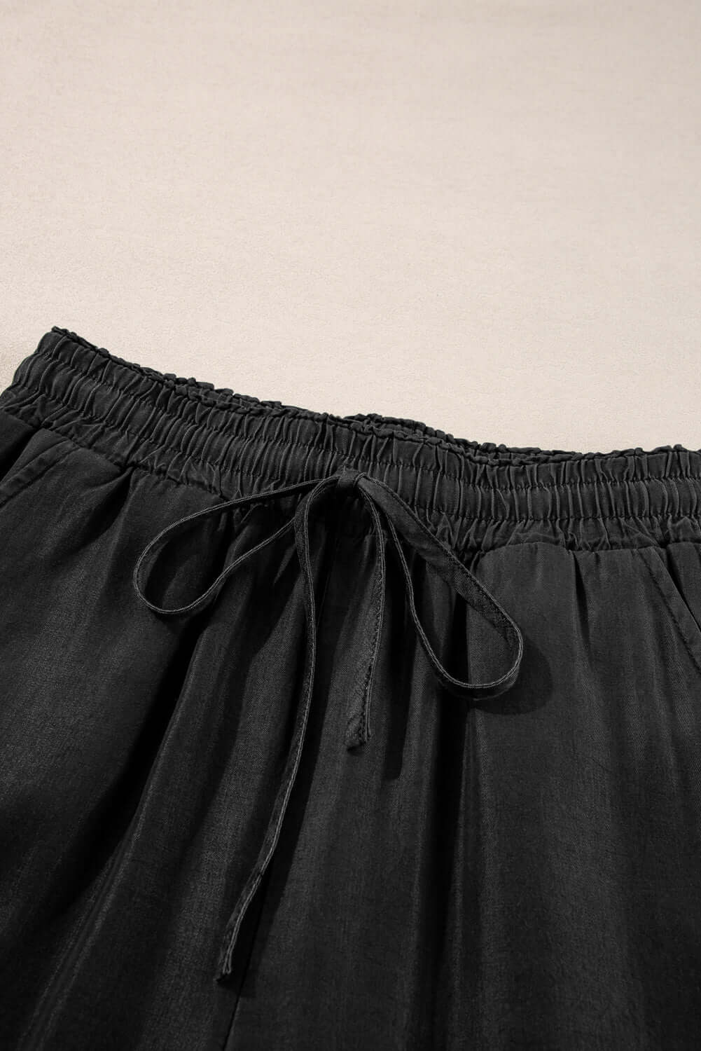 Close-up of Bella Road Drawstring Wide Leg Jeans in black, showcasing the trendy drawstring waist and soft fabric.