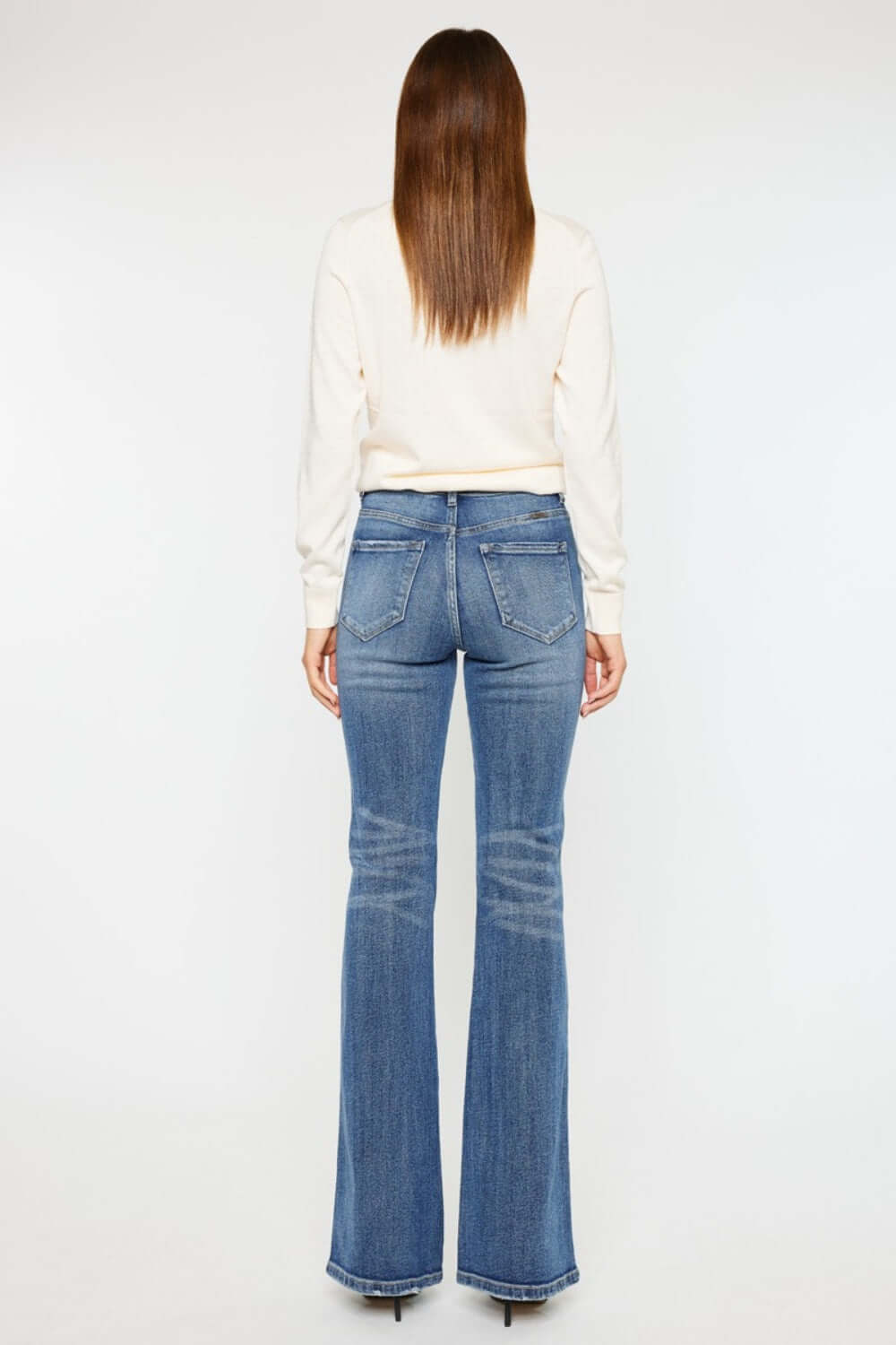 Woman wearing Cat's Whiskers High Waist Flare Jeans showcasing retro high waist and flare leg design from the back.