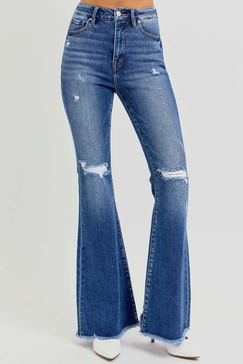 High rise distressed flare jeans with raw hem and retro vibe. Perfect for trendy looks with ankle boots or heels.