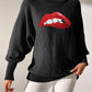 Bella Road Lip Turtleneck Sweater in black with bold red lip design, showcasing unique style and playful fashion statement.