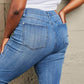 Woman wearing Janavie full-size high waisted pull on skinny jeans with release hem detailing, showcasing back view. Judy Blue Jeans.