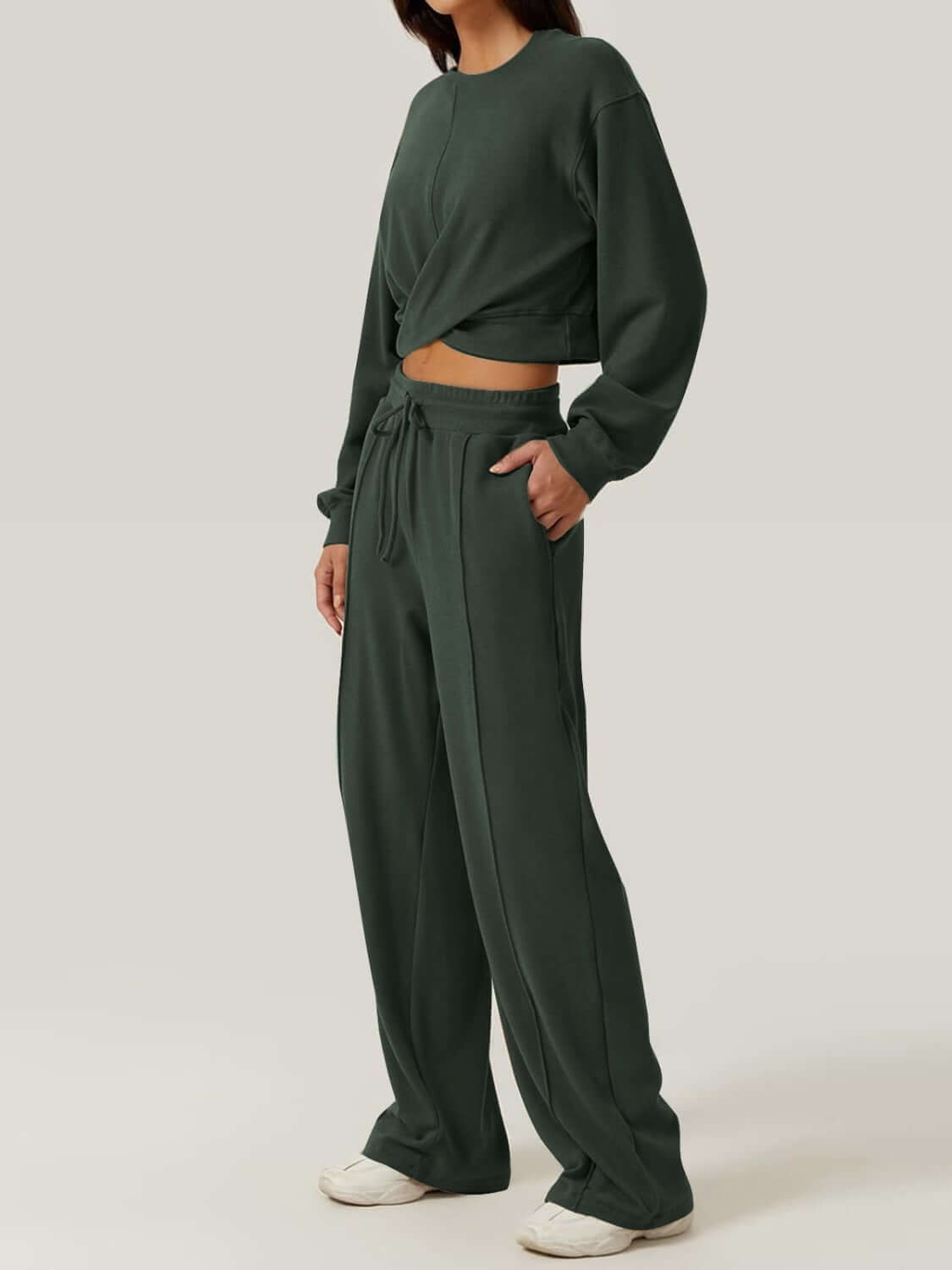 Woman wearing Bella Road Crisscross Round Neck Top and Drawstring Pants Set in dark green, showcasing comfortable and stylish casual wear.