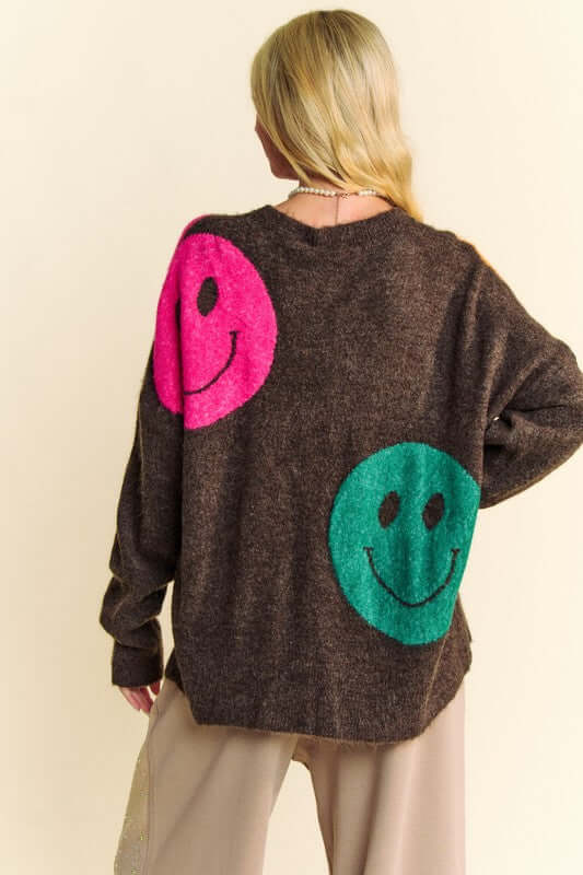 Oversize sweater with playful pink and green smiley faces, perfect for a cozy and trendy casual look.