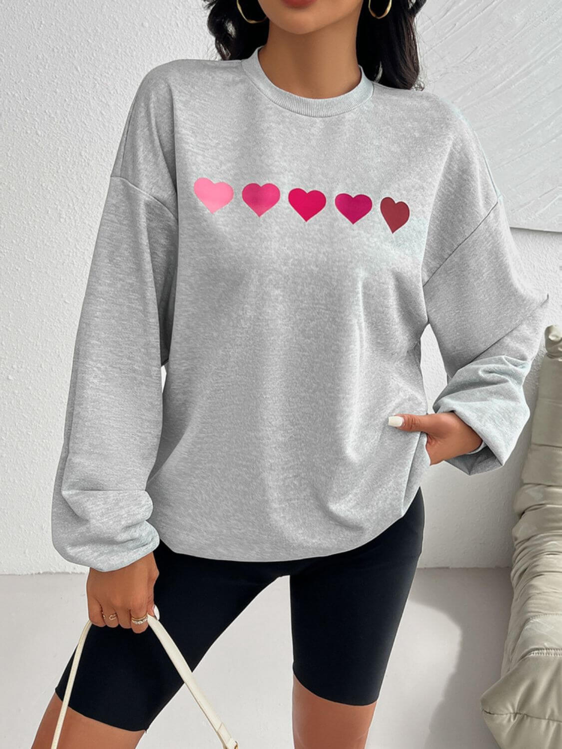 Gray Devine Heart Dropped Shoulder Long Sleeve Sweatshirt with pink heart design worn by a model