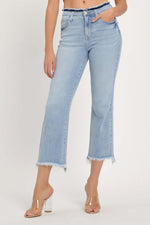 Woman wearing RISEN Full Size High Rise Raw Edge Crop Jeans with a raw hem, washed denim finish, and slightly stretchy material.