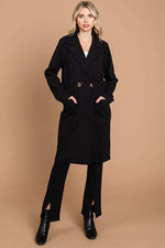 Stylish woman wearing a double-breasted black lapel collar coat, showcasing elegance and chic fashion.