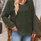 Woman wearing a drawstring dropped shoulder long sleeve hoodie in dark green paired with blue jeans.