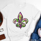 Bella Road Mardi Gras white t-shirt featuring a vibrant green and purple fleur-de-lis graphic design. Perfect for festive celebrations!