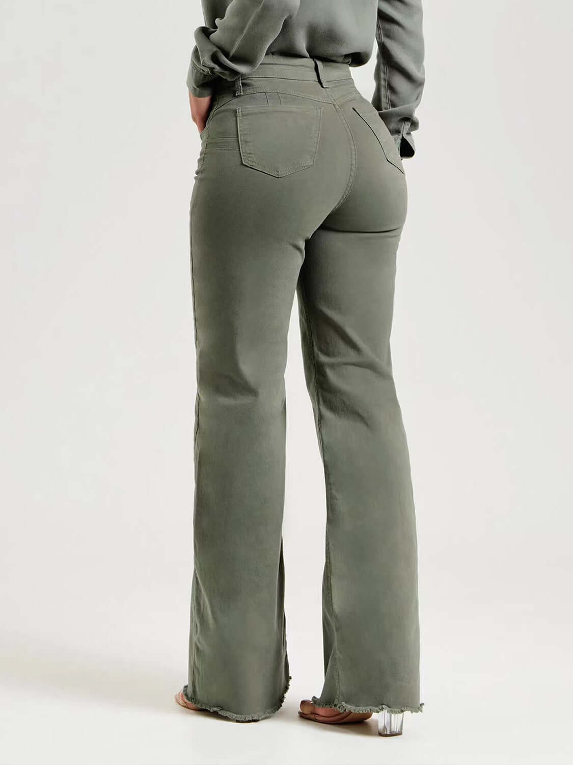 Woman wearing buttoned raw hem jeans with pockets, slightly stretchy, 97% cotton and 3% elastane, comfortable fit.