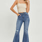 Woman wearing high waist distressed flare jeans - Risen Jeans - with a trendy urban chic look and vintage-inspired style