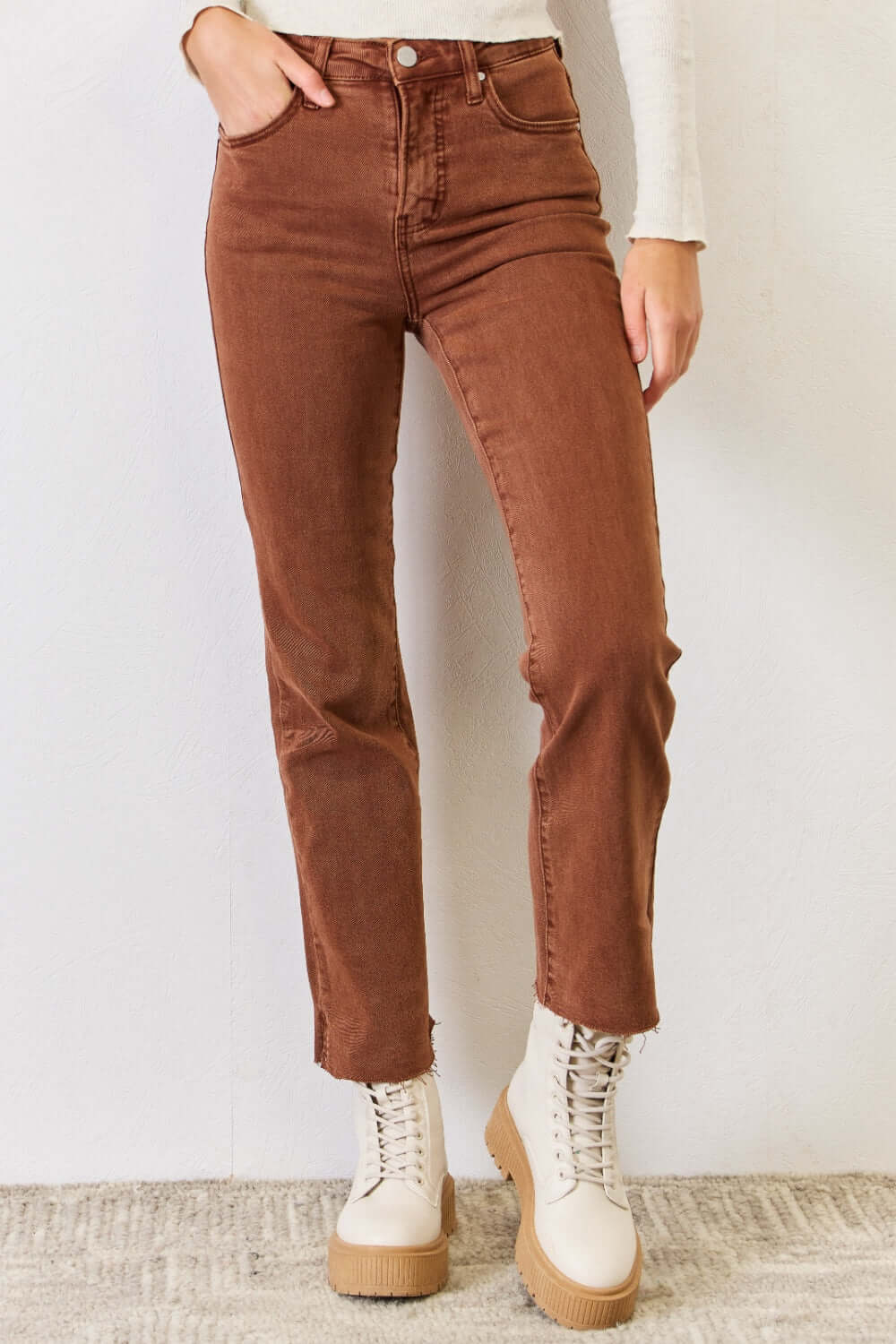 High Rise Tummy Control Straight Jeans with raw hem in brown, modeled with white boots - Risen Jeans