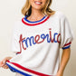 Woman wearing a metallic America letter short sleeve sweater with red, white, and blue detailing. Trendy and patriotic fashion.