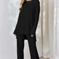 Ribbed High-Low Top and Wide Leg Pants Set in black, featuring slightly stretchy material, modeled by a woman.