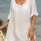 Woman wearing a white tied ruffled half sleeve cover-up made of sheer cotton and polyester blend, perfect for beachwear.