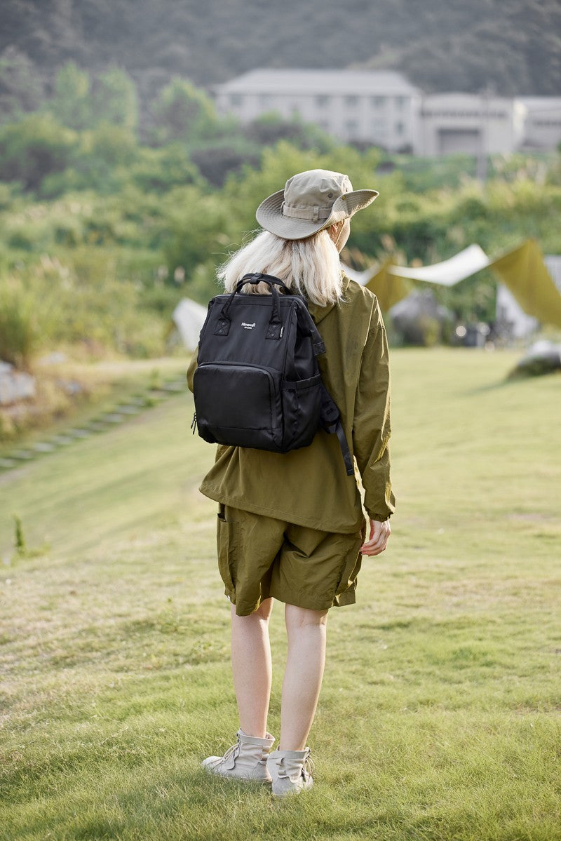 Stylish woman wearing Himawari waterproof anti-theft nylon backpack in nature setting