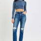 Trendy high rise distressed crop jeans paired with a chic blue top and black boots for an edgy fashion statement.