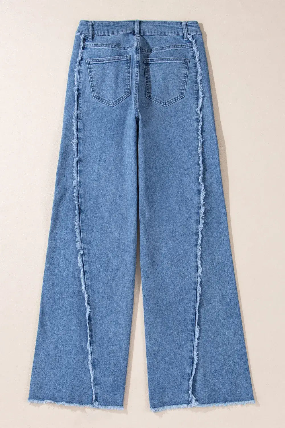 Back view of Bella Road Raw Hem Wide Leg Jeans with Pockets, showcasing the unique raw hem and wide leg design in a light blue denim.