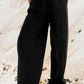 Woman wearing Bella Road Drawstring Wide Leg Jeans in black, showcasing a comfortable and stylish wide leg design.