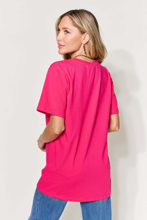 Woman wearing a pink MAMA round neck short sleeve T-shirt, viewed from the back.