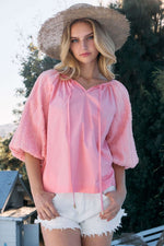 Woman wearing pink Poplin Bubble Sleeve Blouse with white shorts and a wide-brimmed hat outdoors