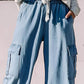 Light wash wide leg cargo jeans with drawstring waist, perfect for a stylish casual look.