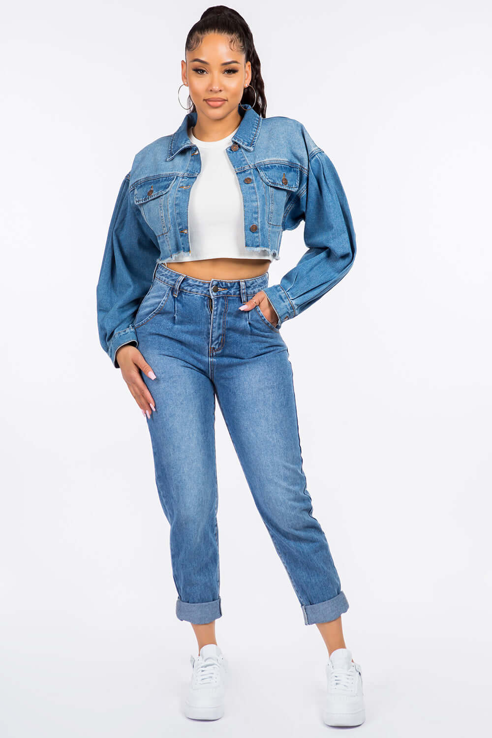 Woman wearing High Waist Pleated Waist Mom Jeans paired with a cropped denim jacket and white sneakers