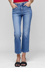 Model wearing RISEN full size tummy control high rise crop straight jeans in light blue wash with fashionable cropped length.